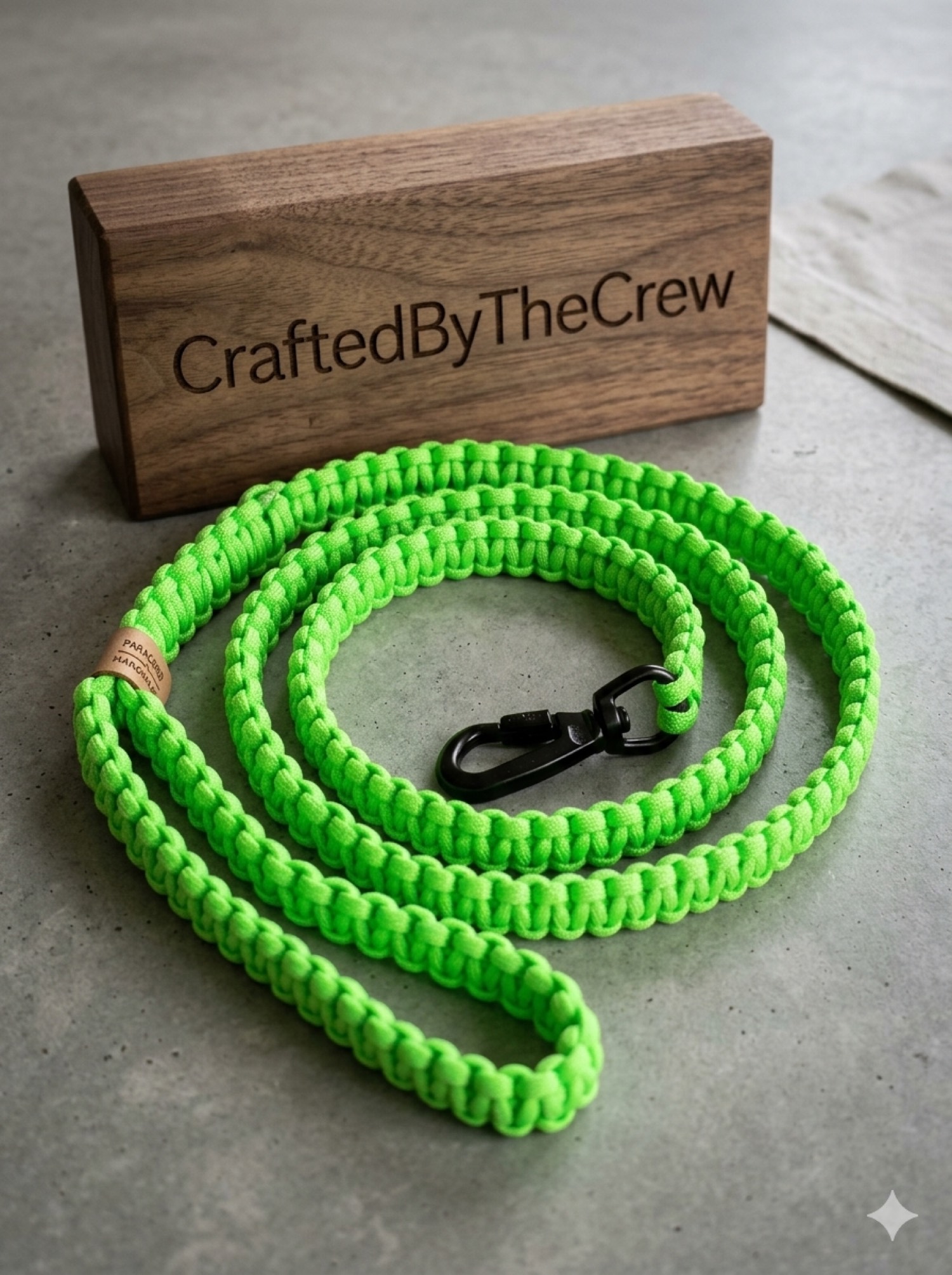 Neon green paracord dog leash coiled beside a wooden Crafted By The Crew block