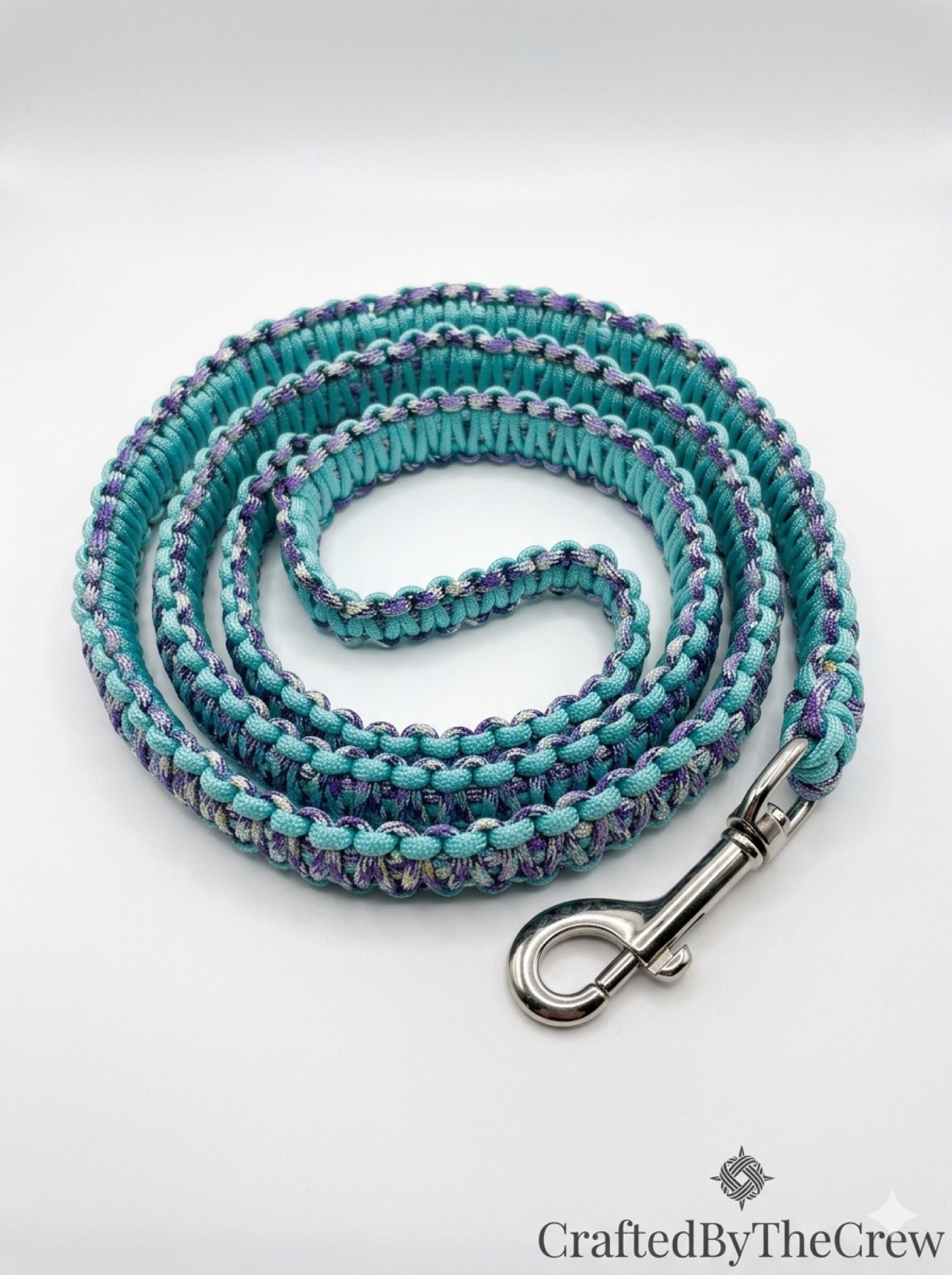 Teal and violet paracord leash coiled with a silver snap
